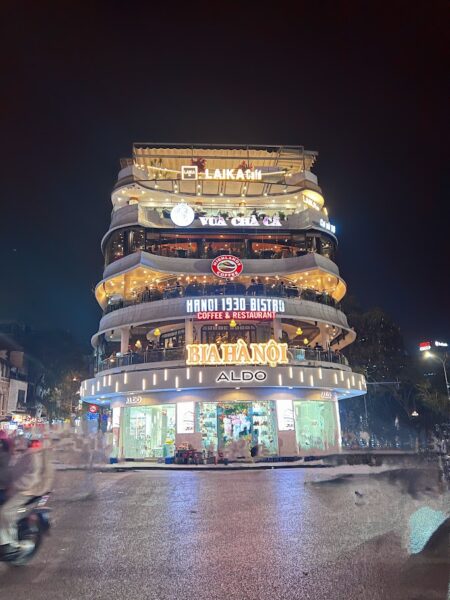 Hanoi 1930 Bistro – neon-lit café in the city centre at night  AKA The Shark Building