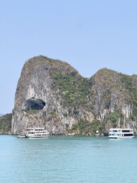 Ha Long Bay limestone island with a natural cave visible from the water.