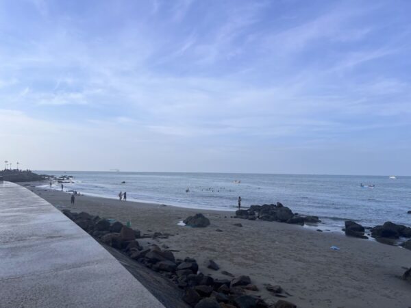 Vũng Tàu beachfront promenade with rocks and waves at low tide.