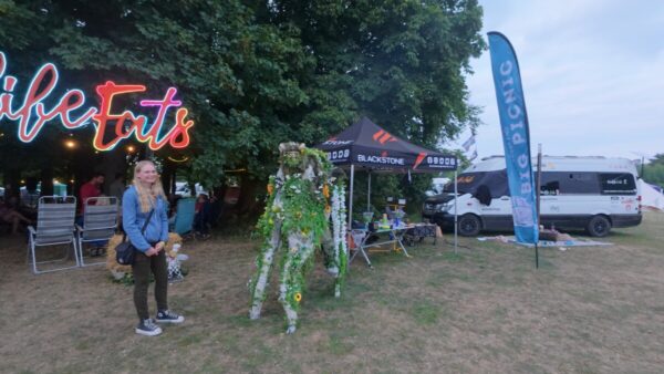 Food stalls and quirky displays, including a performer dressed as a walking green plant creature