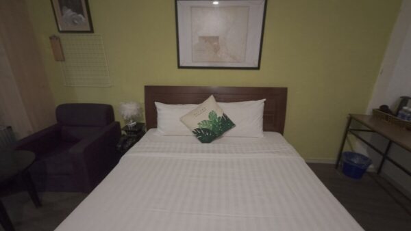 Guesthouse room with bed and chair